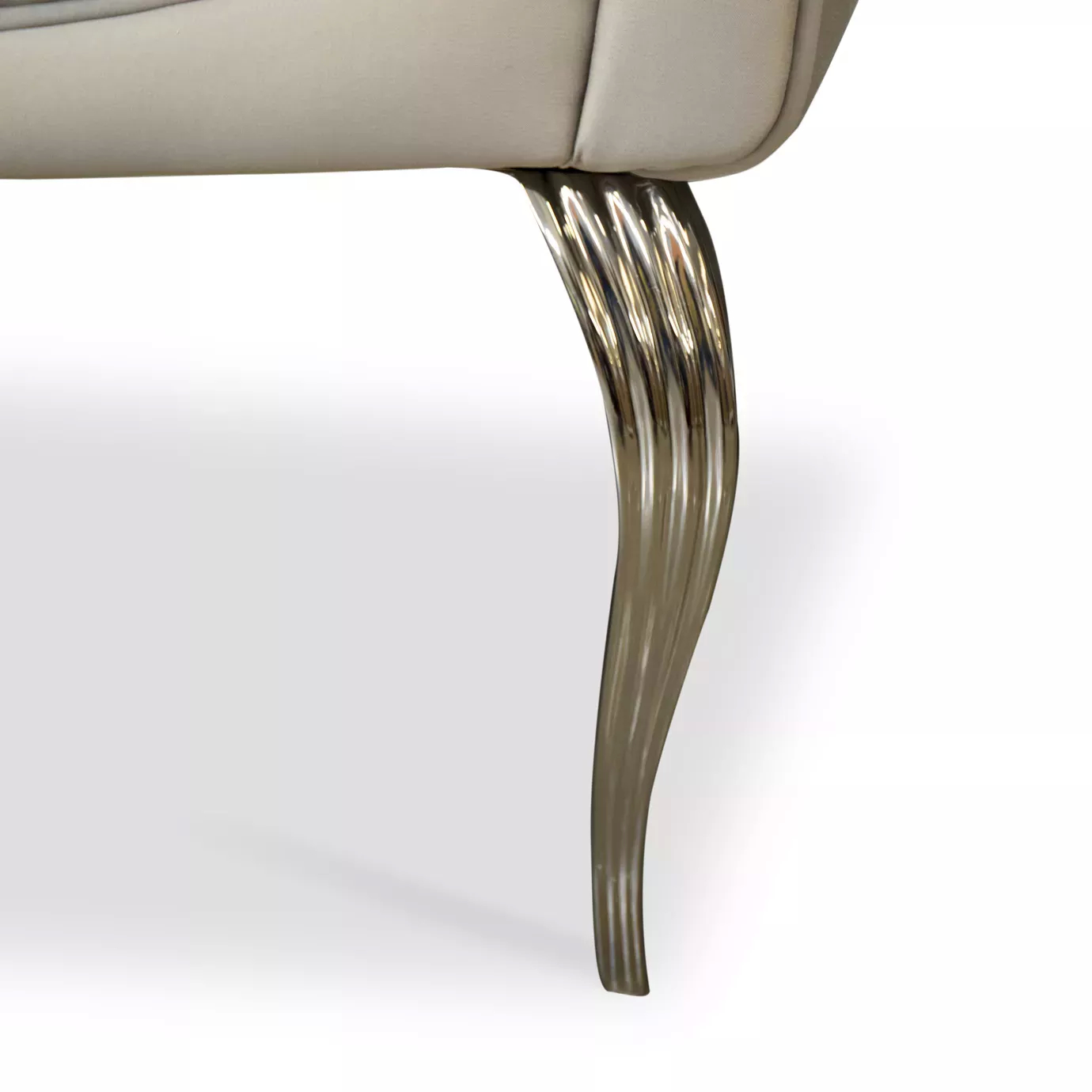 Elegant close-up detail of a curved and fluted silver metal leg of the Caprichosa Sofa's base.