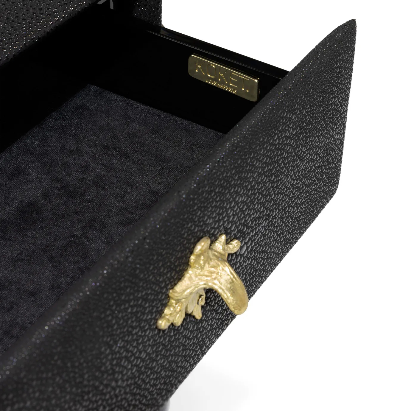 Elegant close-up detail of a partially opened black drawer of the Temptation Console, revealing the interior and a decorative golden star-shaped handle. A golden label with the word "KOKET" is visible inside the drawer.