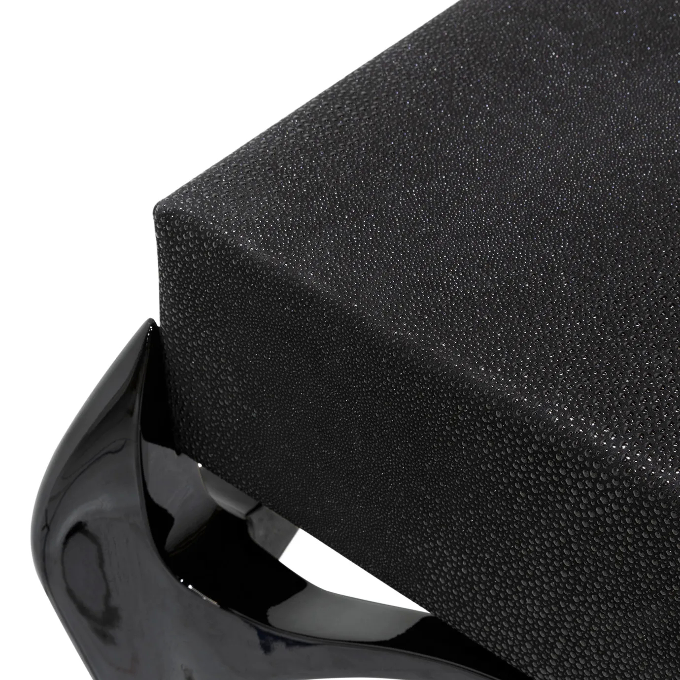 Elegant close-up detail of the textured black tabletop of the Temptation Console and its glossy curved connection to the black leg.
