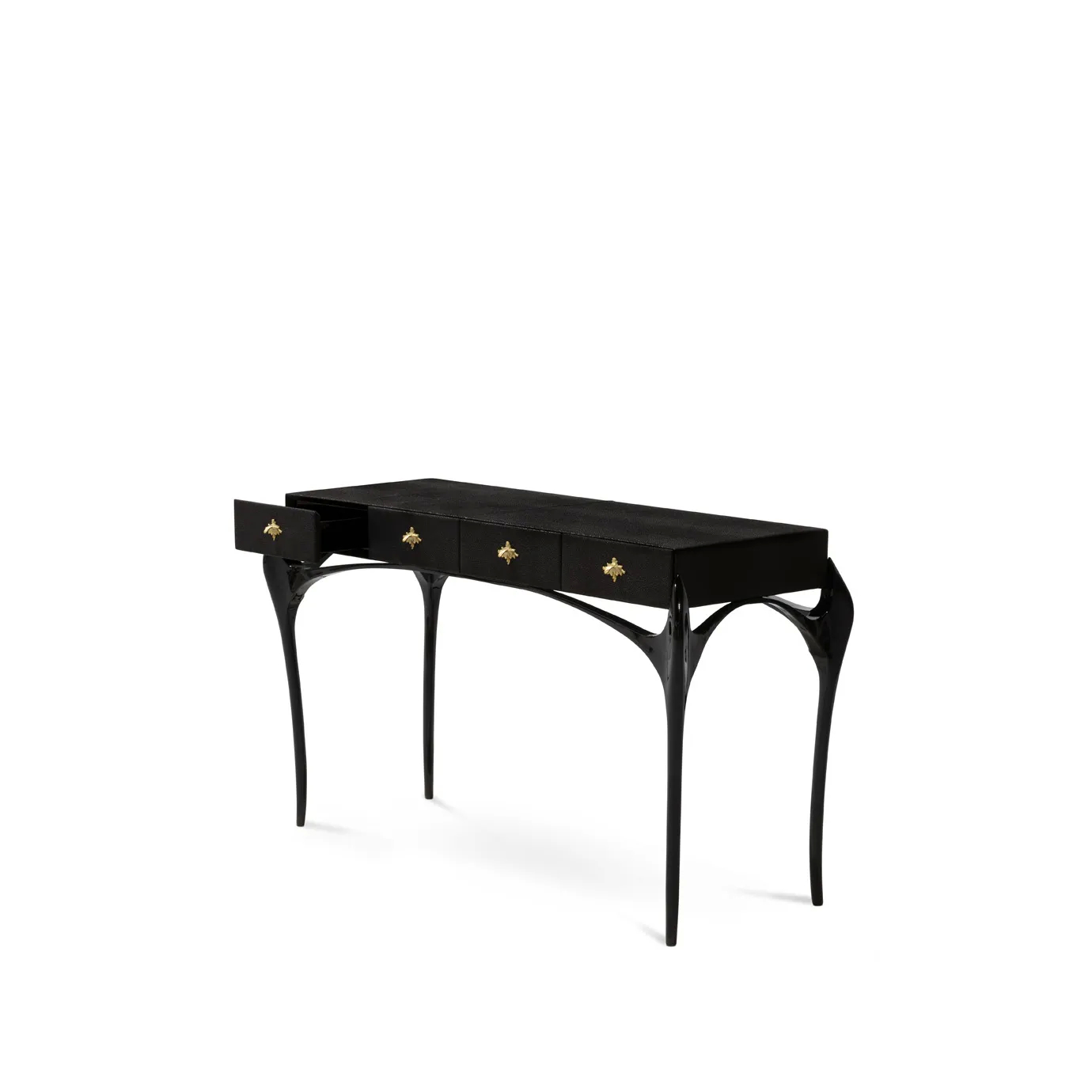 Elegant Temptation Console with a long black tabletop featuring four drawers, one of which is open, adorned with decorative golden star-shaped handles, and a frame with curved black legs and a sculptural golden detail at the base, viewed from a side angle.