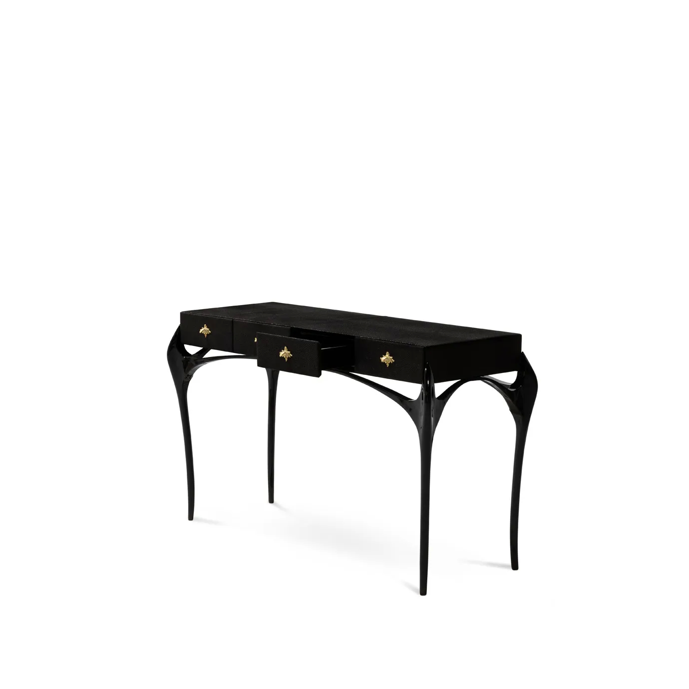 Elegant Temptation Console with a long black tabletop featuring four drawers, two of which are partially open, adorned with decorative golden star-shaped handles, and a frame with curved black legs and a sculptural golden detail at the base, viewed from a side angle.