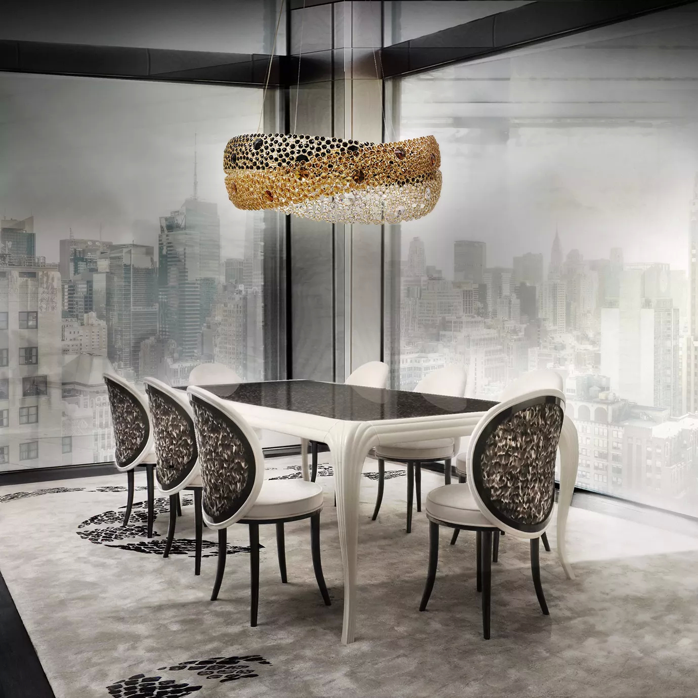 Elegant and modern dining room featuring the Merveille Dining Table with a dark top and a curved white base, surrounded by Merveille Dining Chairs with backrests adorned with a brown and black feather pattern and white upholstery, beneath a modern and sculptural chandelier with golden and black elements, in a space with large windows overlooking a cityscape, a light rug with a black and white abstract pattern, and grey-toned walls.