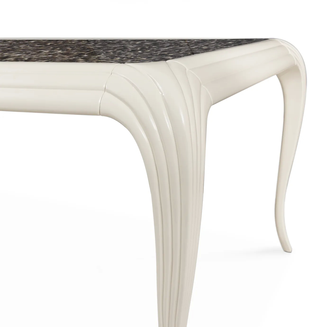 Elegant close-up detail of the connection between the tabletop adorned with an exotic feather pattern and the curved leg with vertical textured details of the Merveille Dining Table.