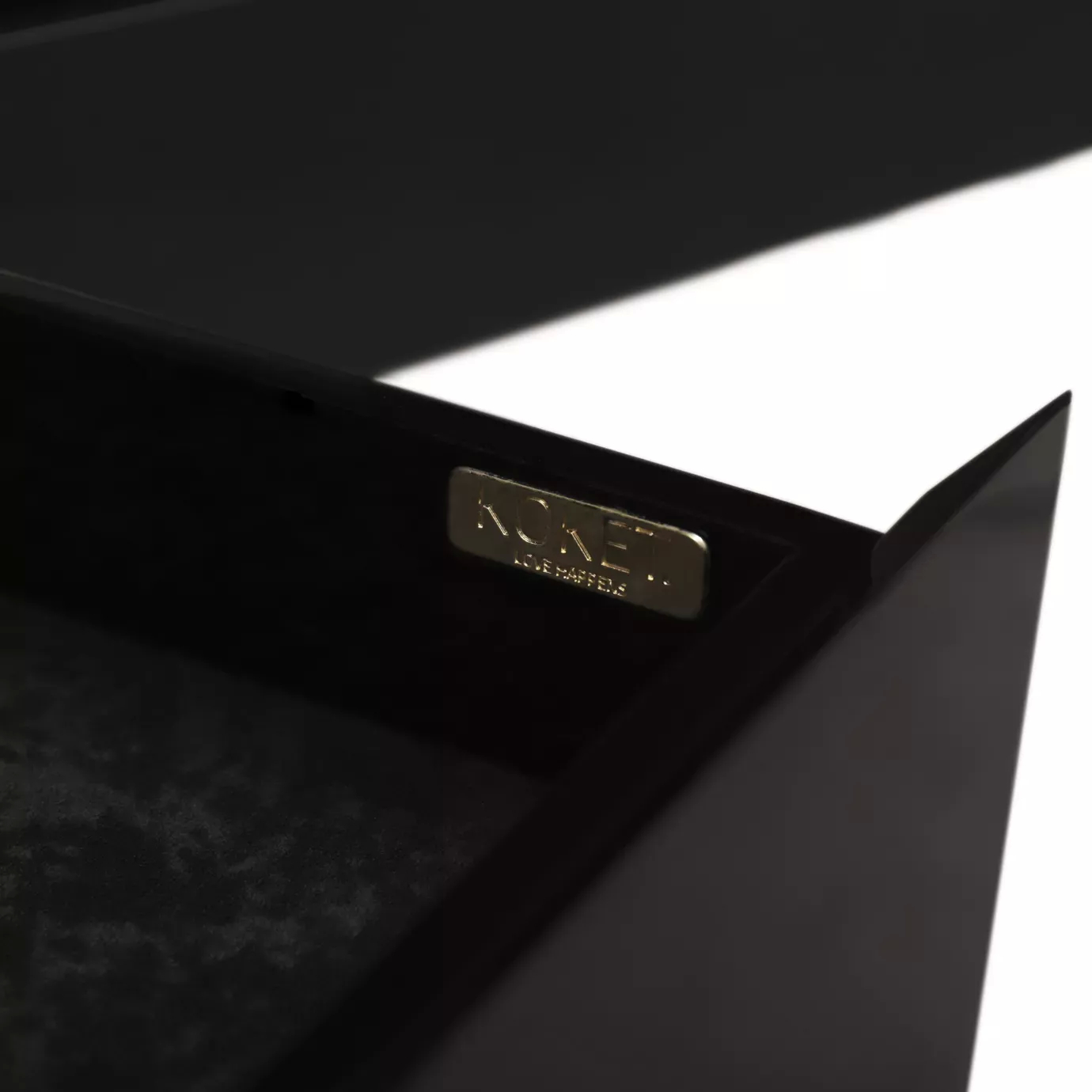 Elegant close-up detail of a golden label inscribed with "KOKET LOVE HAPPENS" inside a dark drawer of the Temptation Bar Cabinet.