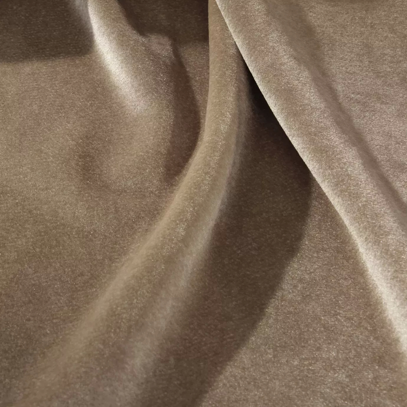 Elegant close-up of a Silky Velvet fabric swatch in a soft and luminous rosy beige tone, showcasing its smooth texture and the flowing folds that highlight its delicate sheen