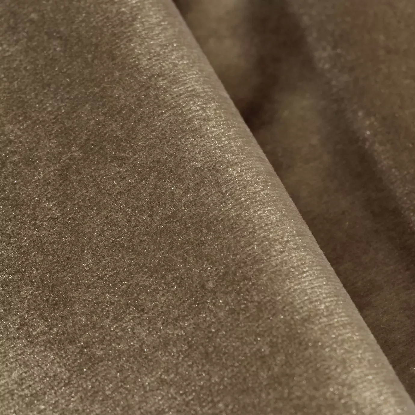 Elegant close-up of a Silky Velvet fabric swatch in a soft and luminous light brown tone, showcasing its smooth and lustrous texture with gentle folds that catch the light.