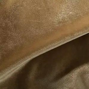 Elegant close-up of a Silky Velvet fabric swatch in a soft and luminous golden tone, showcasing its smooth and shiny texture with gentle folds that highlight its silky sheen.