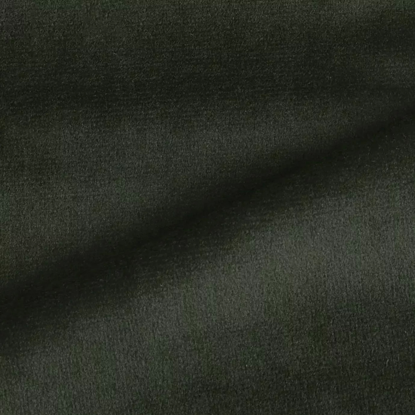 Elegant close-up of a Radiance Velvet fabric swatch in a deep and rich forest green tone, showcasing its velvety texture and the gentle folds that give it a feeling of luxury and depth.