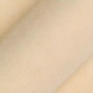 Soft and elegant close-up of a Lux Velvet fabric swatch in a light and luminous cream tone, showcasing its velvety texture and a delicate sheen that gives it a feeling of comfort and gentle elegance.