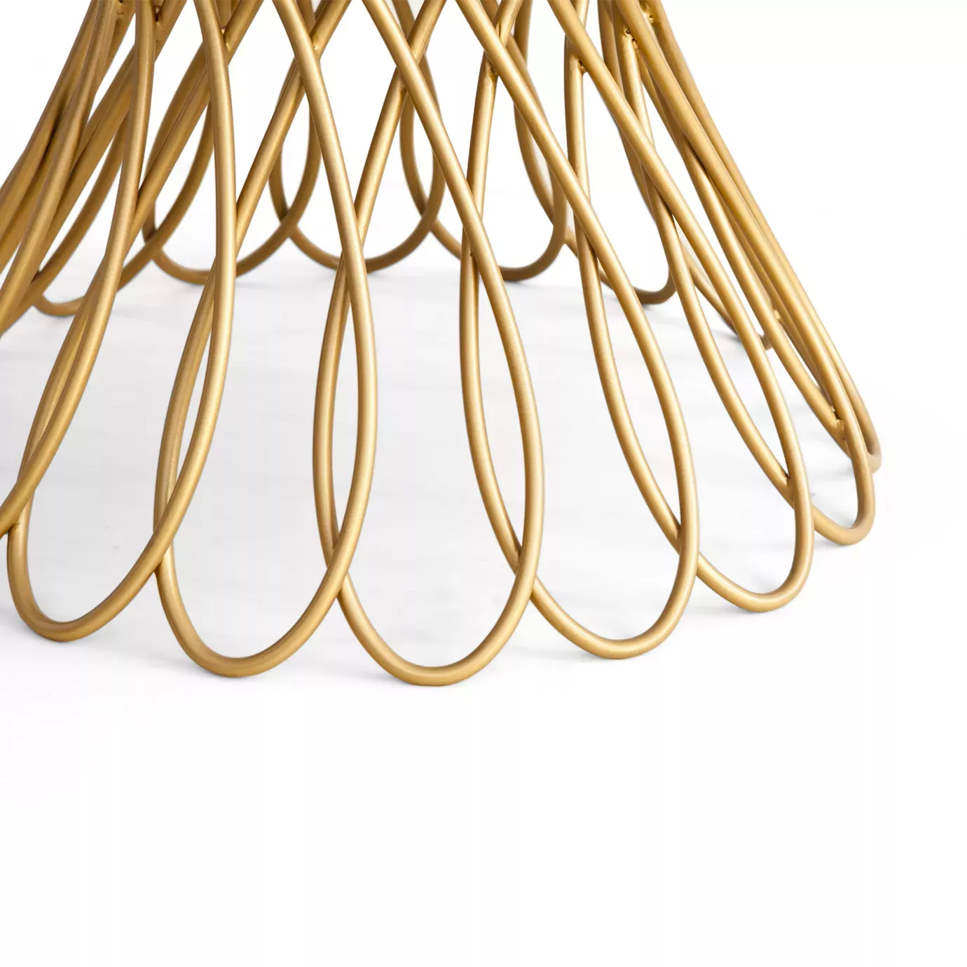 Close look of the Allure Dining Table’s interlaced golden silhouette-shaped structure.