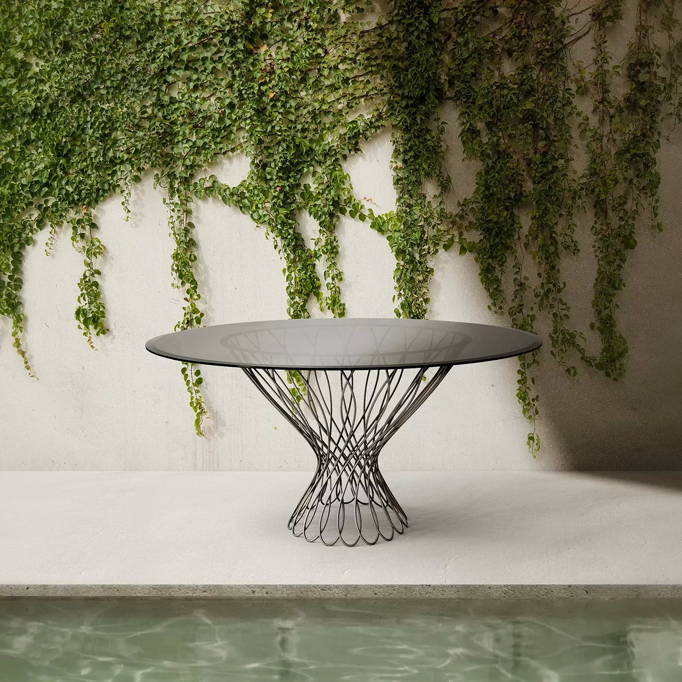 Outdoor setting with an Allure Dining Table set by a pool. The dining table features a sophisticated smoked glass top resting on the interlaced black silhouette-shaped structure.