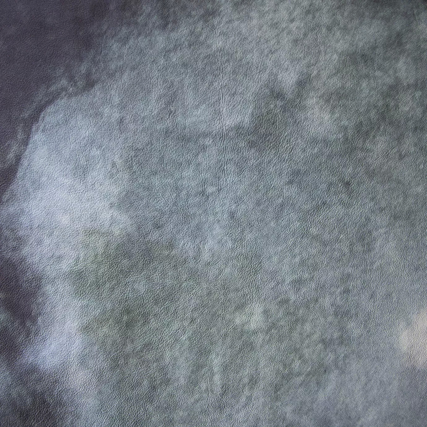Elegant close-up of a Watermark Aqua Leather swatch in a soft aquatic tone with a subtle watermark effect, featuring a natural grain texture that gives it depth and a supple touch, evoking a feeling of freshness and organic elegance.