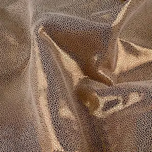 Elegant close-up of a Crico Leather swatch with a textured pattern of small dots in beige and metallic gold tones, featuring a smooth surface with a subtle shimmer, evoking a feeling of understated luxury and textured elegance.
