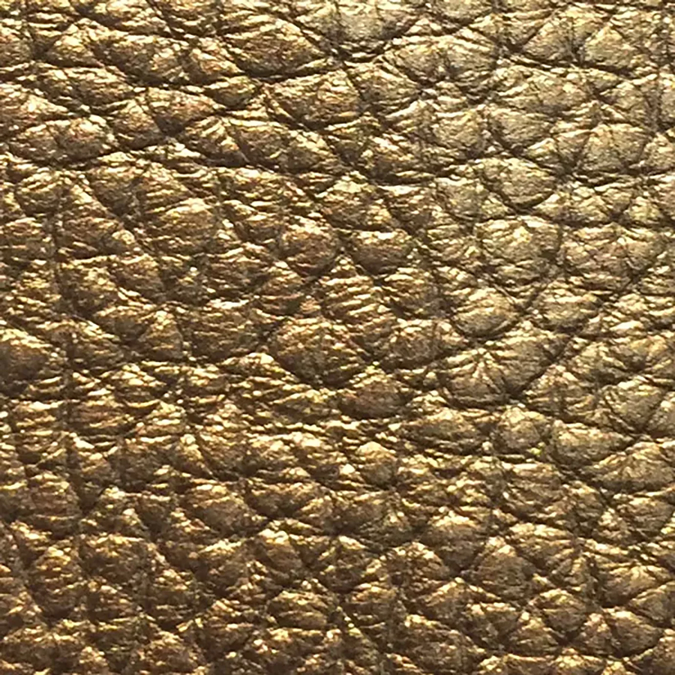 Close-up of a Harbor Leather fabric swatch in a textured, aged gold tone, showcasing its raised areas and grooves that give it a rustic and elegant feel. The soft sheen highlights the depth of its texture.