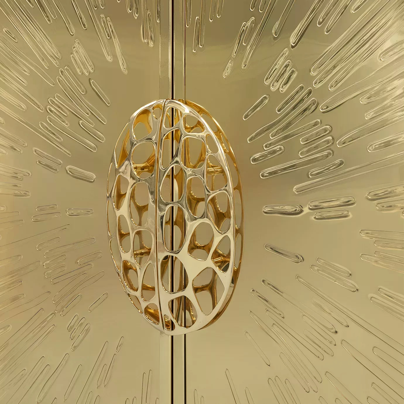 Focus on the sculptural handle of the golden Heive armoire.