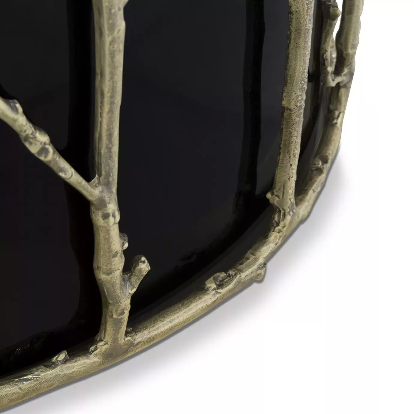 Close look on the Enchanted Glass Top Dining Table’s black structure adorned with intricate aged brass details, resembling branches.