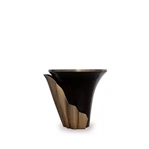 Featuring a sultry silhouette, Yasmine Aged Gold Leaf Side Table has an ebony tabletop with aged brass edges, set on a black wooden base, adorned with an aged gold leaf structure that arches back and forth.