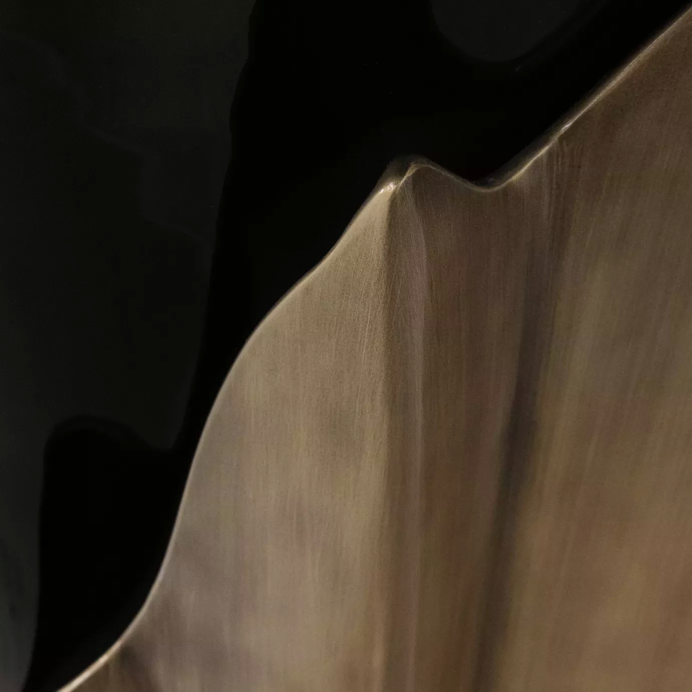 Close look on the Yasmine Aged Gold Leaf Side Table, showcasing its elegant black base and the aged gold leaf structure around it.
