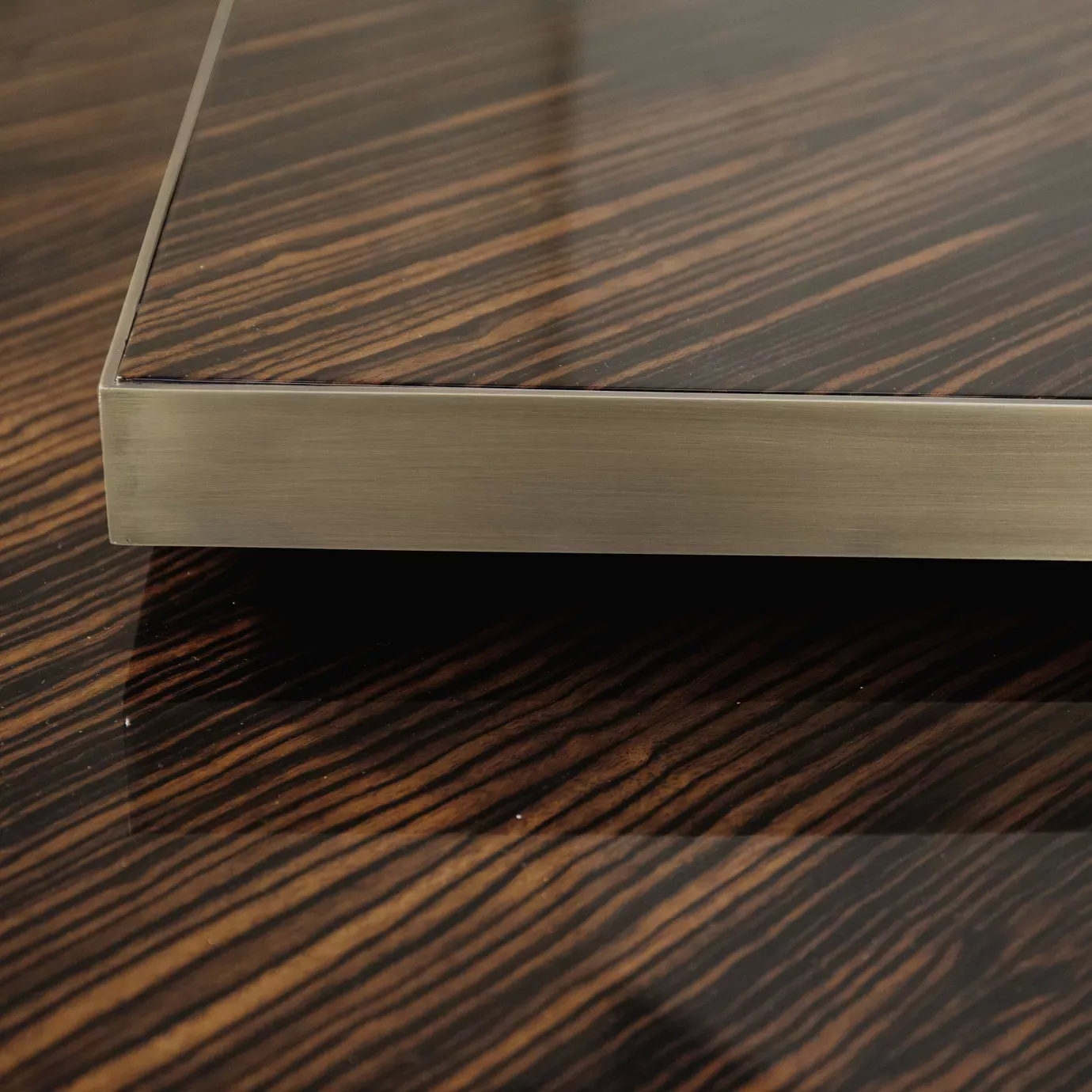 Tears Aged Brass Coffee Table: Close-up detail of the dark wood top and brushed brass edge, showcasing its sleek, modern design.