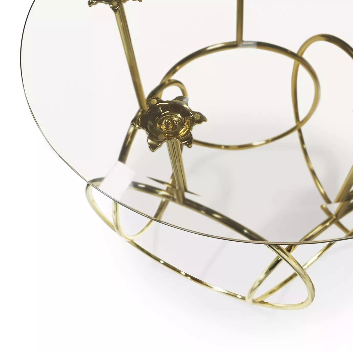 Elegant close-up of the clear glass top and sculptural golden base of the Kiki Side Table.