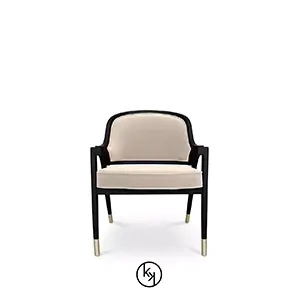 Arendal Chair by KOKET featuring a light beige upholstered seat and curved backrest, framed in dark wood with sleek legs and gold metal-tipped feet.