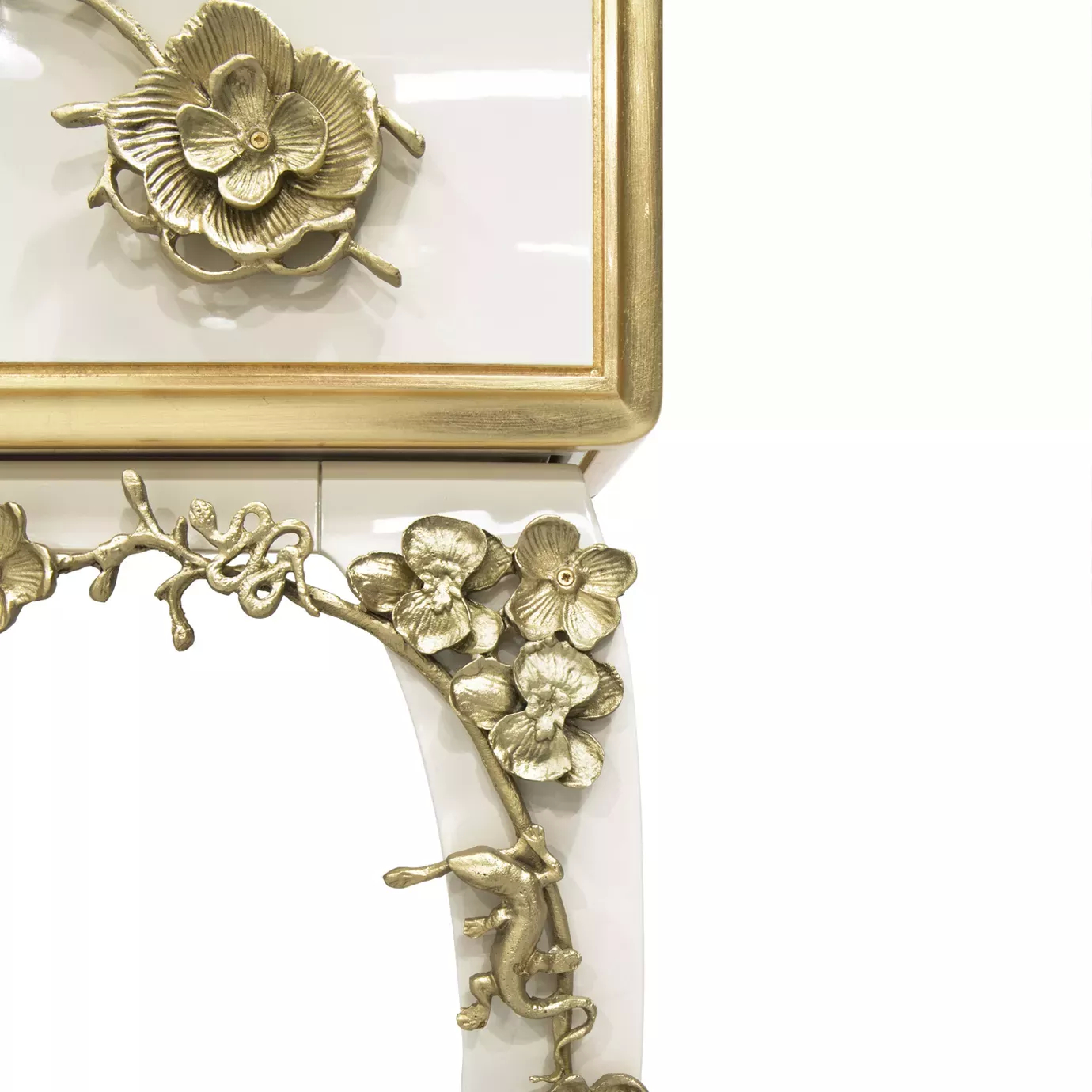 Close look on one of the corners of the Spellbound Lacquer Bar Cabinet, showcasing its golden frame and beautiful floral-themed adorns, combining with the creamy lacquer structure.