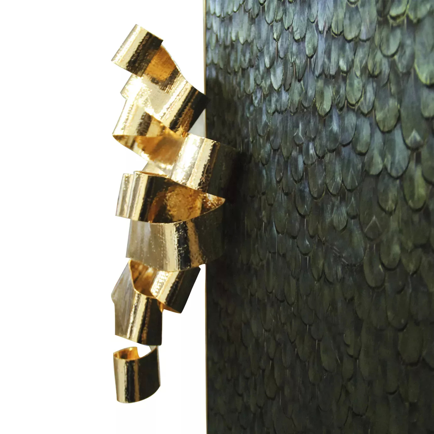 Divine Peacock Feather Armoire: side view of the golden handle resembling a ribbon, contrasting with the dark green peacock feathers that adorn the front doors.