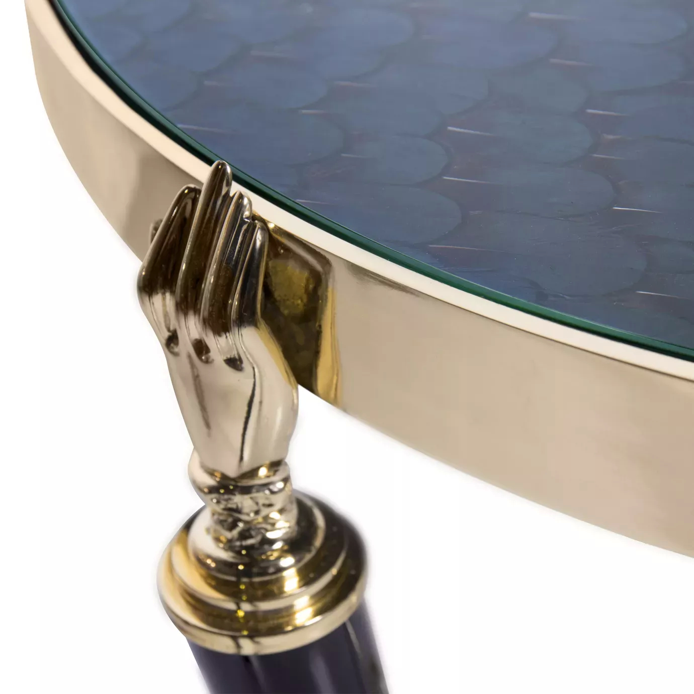 Elegant close-up of the glass top over peacock feather pattern and golden hand detail of the Gisele Side Table.