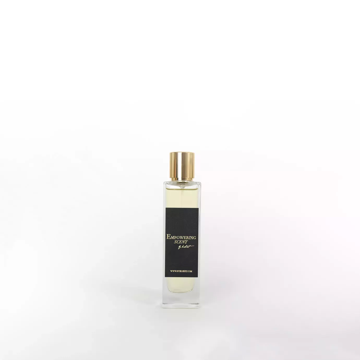 Empowering Scent perfume in a clear glass bottle with a gold cap and black label.