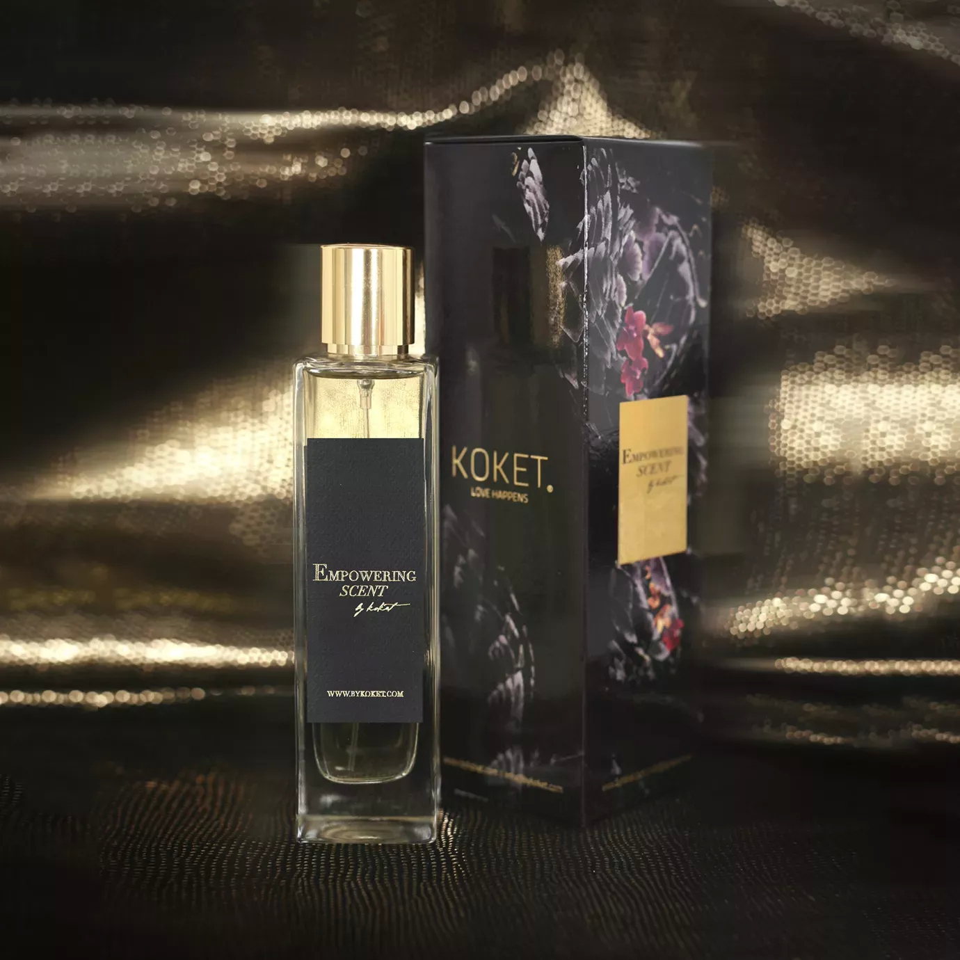 Empowering Scent perfume: clear bottle with gold cap and black label, next to its dark floral box on a shimmering gold background.