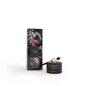 Empowering Diffuser with a black bottle, gold cap, and reeds, next to its packaging with floral and text details.
