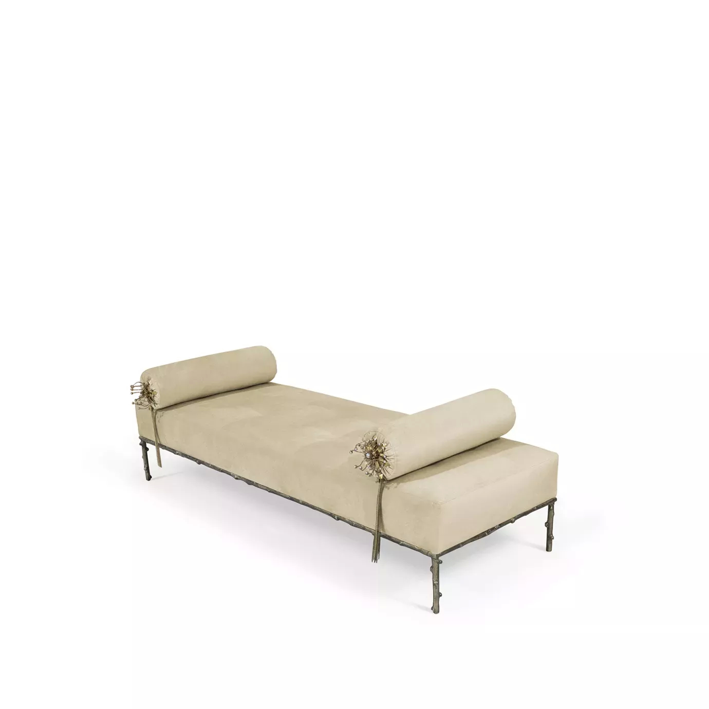 Slightly angled Privê Bench, a cream velvet chaise with decorative bolster pillows featuring tassels, on a detailed metal frame.