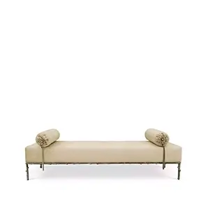 Privê Bench, a cream-colored velvet chaise lounge with two decorative bolster pillows and a detailed metal base.