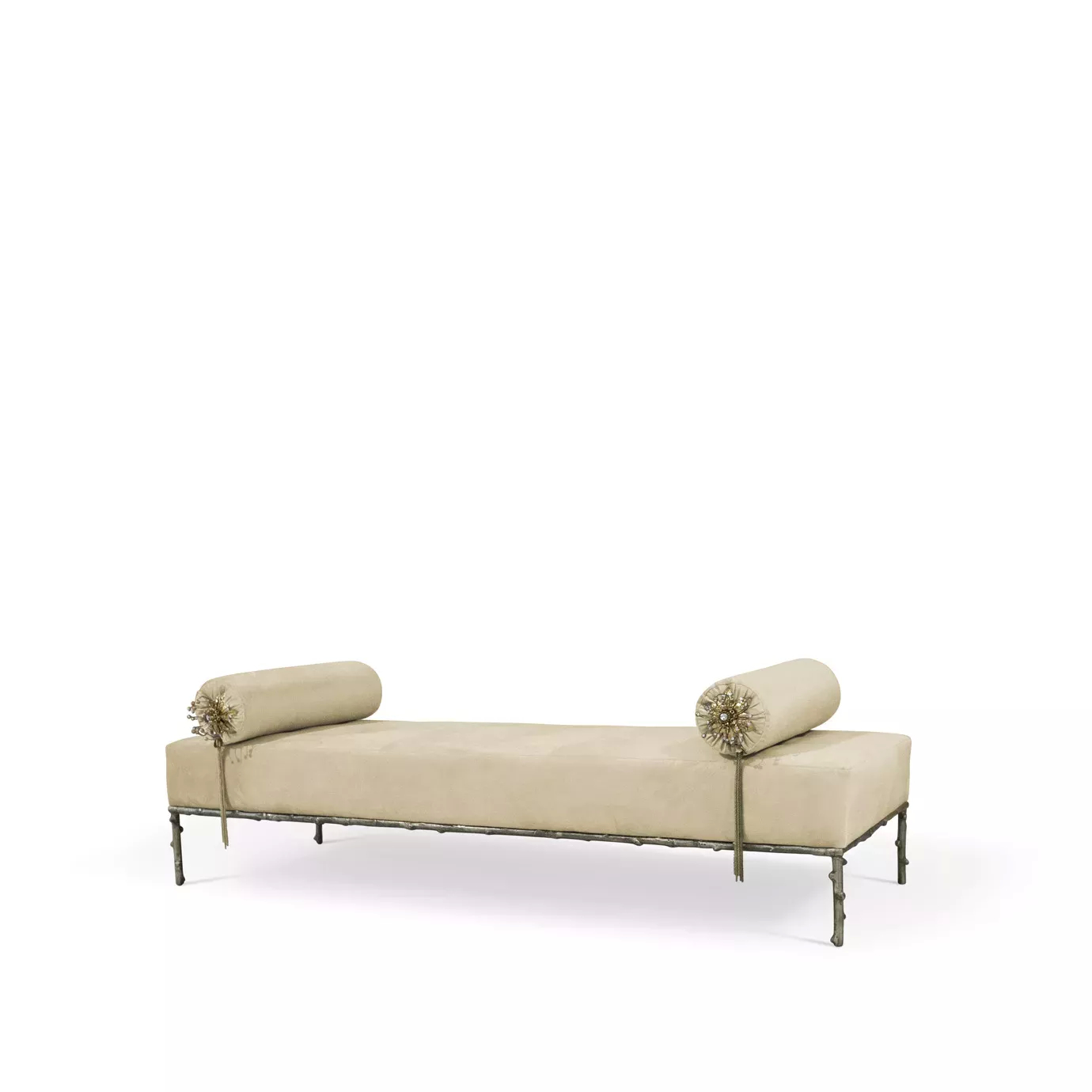 Privê Bench, a cream velvet chaise with decorative bolster pillows featuring tassels, and a detailed metal frame.