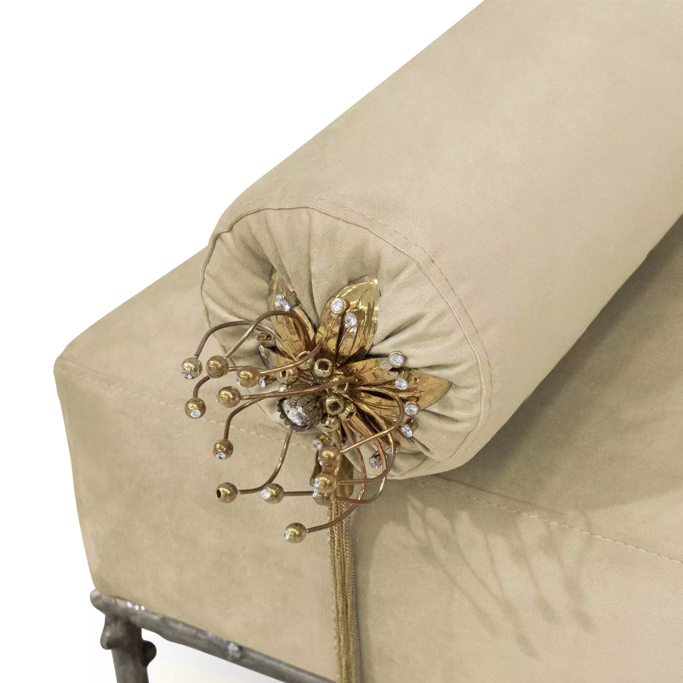 Close-up of Privê Bench, highlighting the cream velvet and a bolster pillow decorated with a golden flower and dangling beaded tassels.