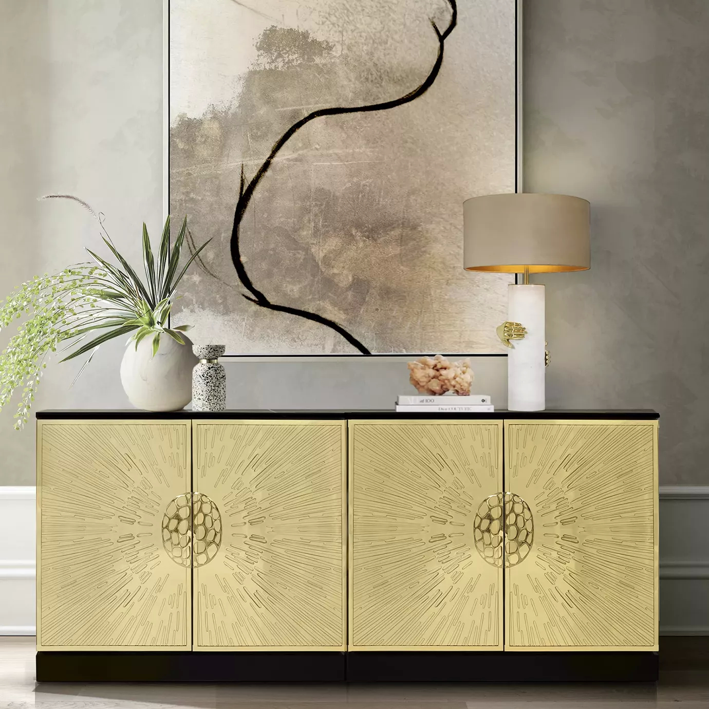 Heive Cabinet in a room setting, featuring golden radiating doors with textured handles, a black top, styled with decor and a lamp.