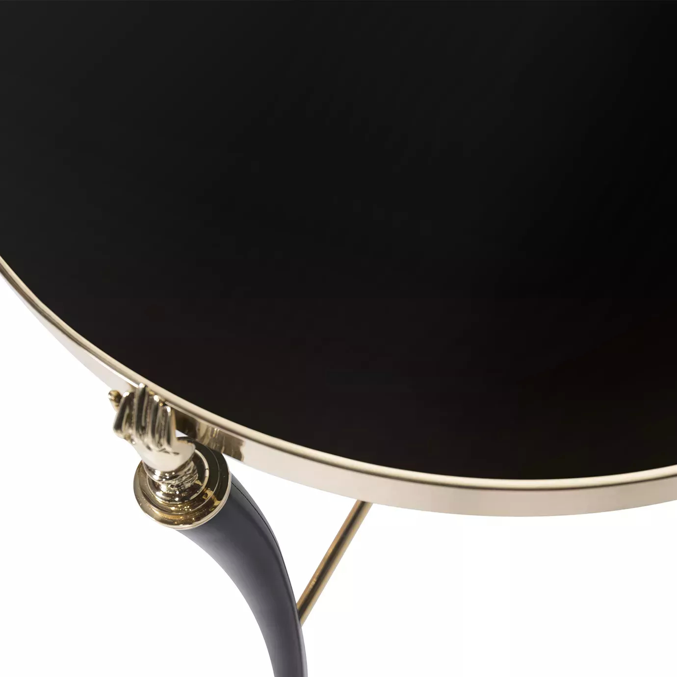 Close-up of the Gisele Lacquer Side Table, featuring a golden hand detail connecting to the glossy black tabletop with a golden edge.