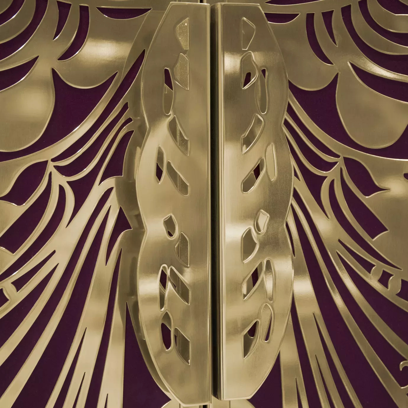 Detail of the Mademoiselle armoire doors with golden butterfly pattern.