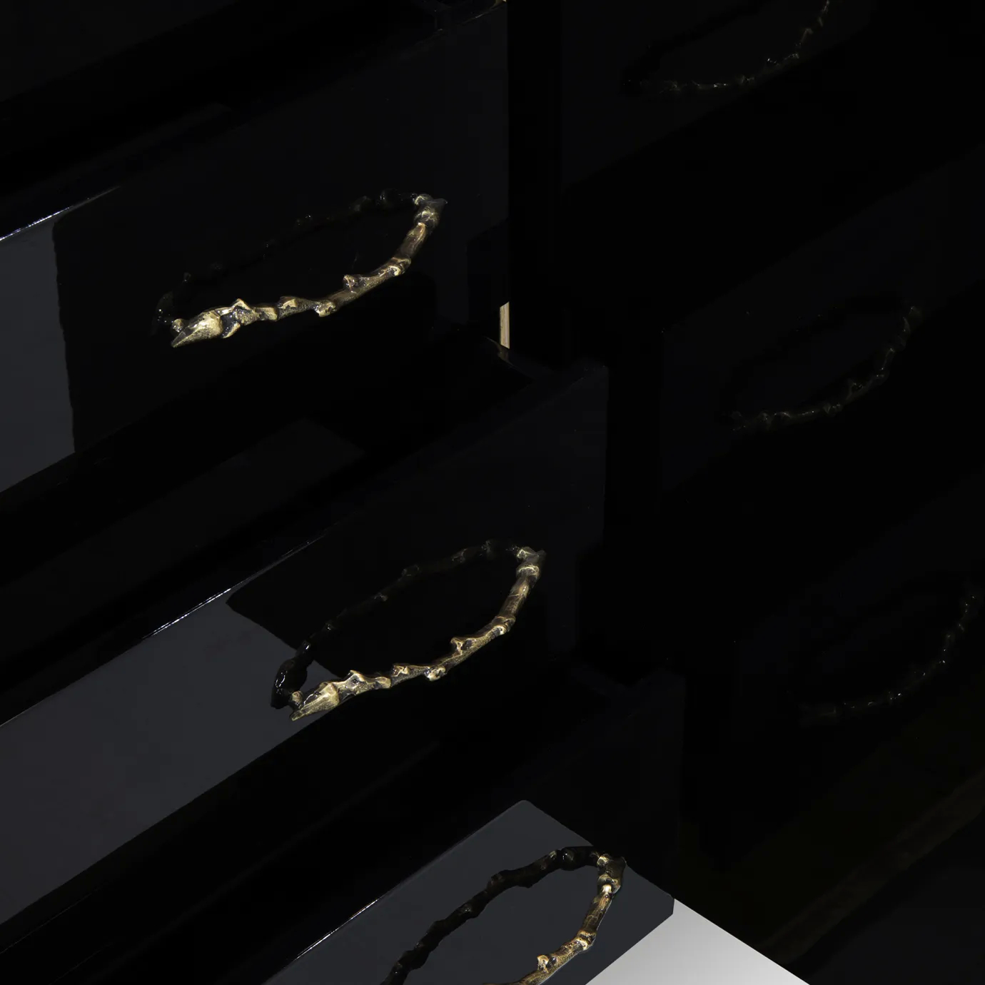 Close-up of the Spellbound Armoire's interior, showing open black drawers with ornate golden branch-like handles.