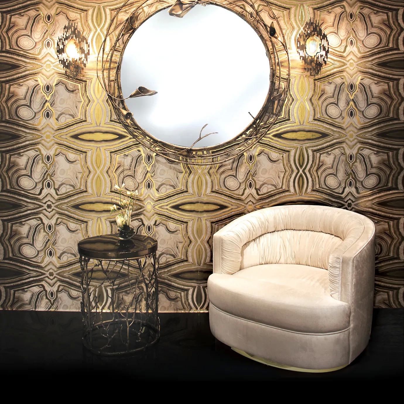 With a patterned wallcovering, this space features a white armchair, an Enchanted Ebony Veneer Top Side table, with a brown tabletop combining with the intricate aged brass structure resembling branches. Above the armchair, there’s a mirror with flower-motifs.