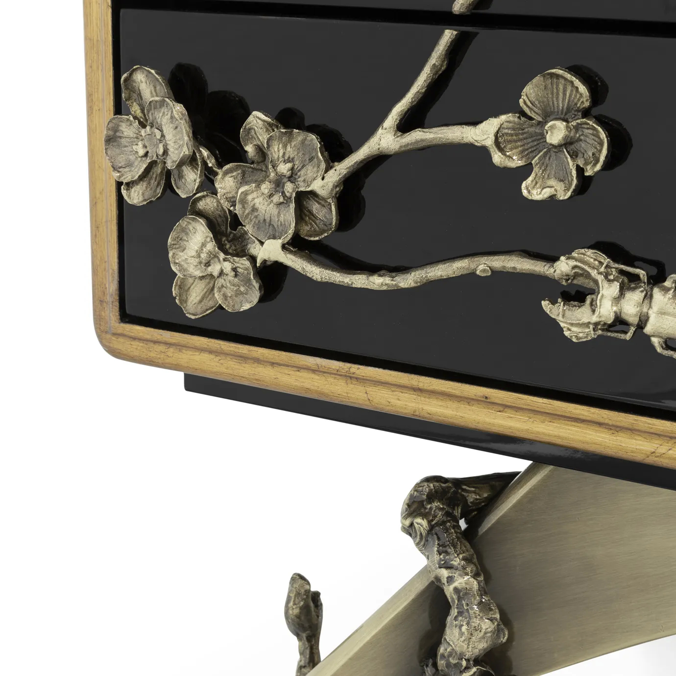Close-up of the Spellbound Nightstand, highlighting the glossy black lacquer, ornate golden floral details, and sculptural metallic legs.