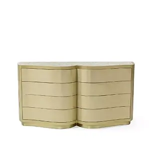 The Poêm Chest features a unique, curved golden design with four drawers and a light-colored, textured top.