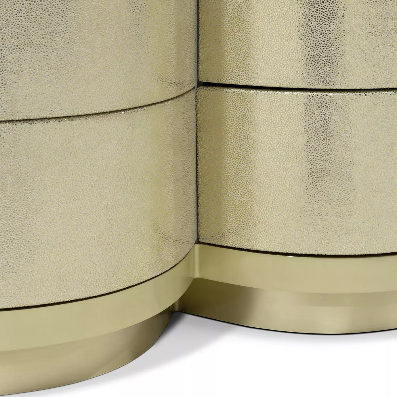 Close-up view of the Poêm Chest, highlighting the textured golden material, curved drawer fronts, and the light reflecting off the surface.