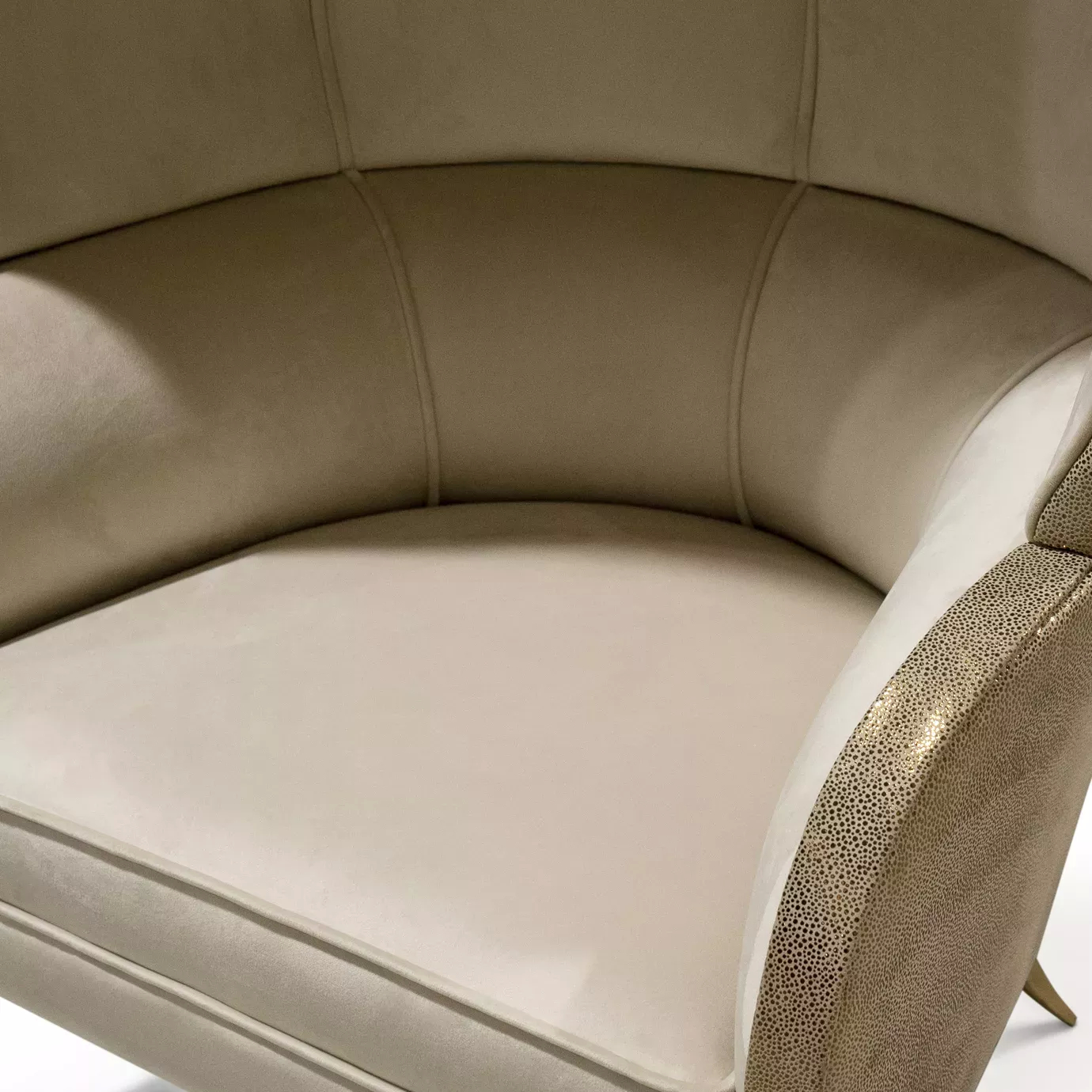 Close-up of the Drapesse Leather Back Chair, highlighting the textured leather with a subtle sheen and the smooth, light-colored inner upholstery.