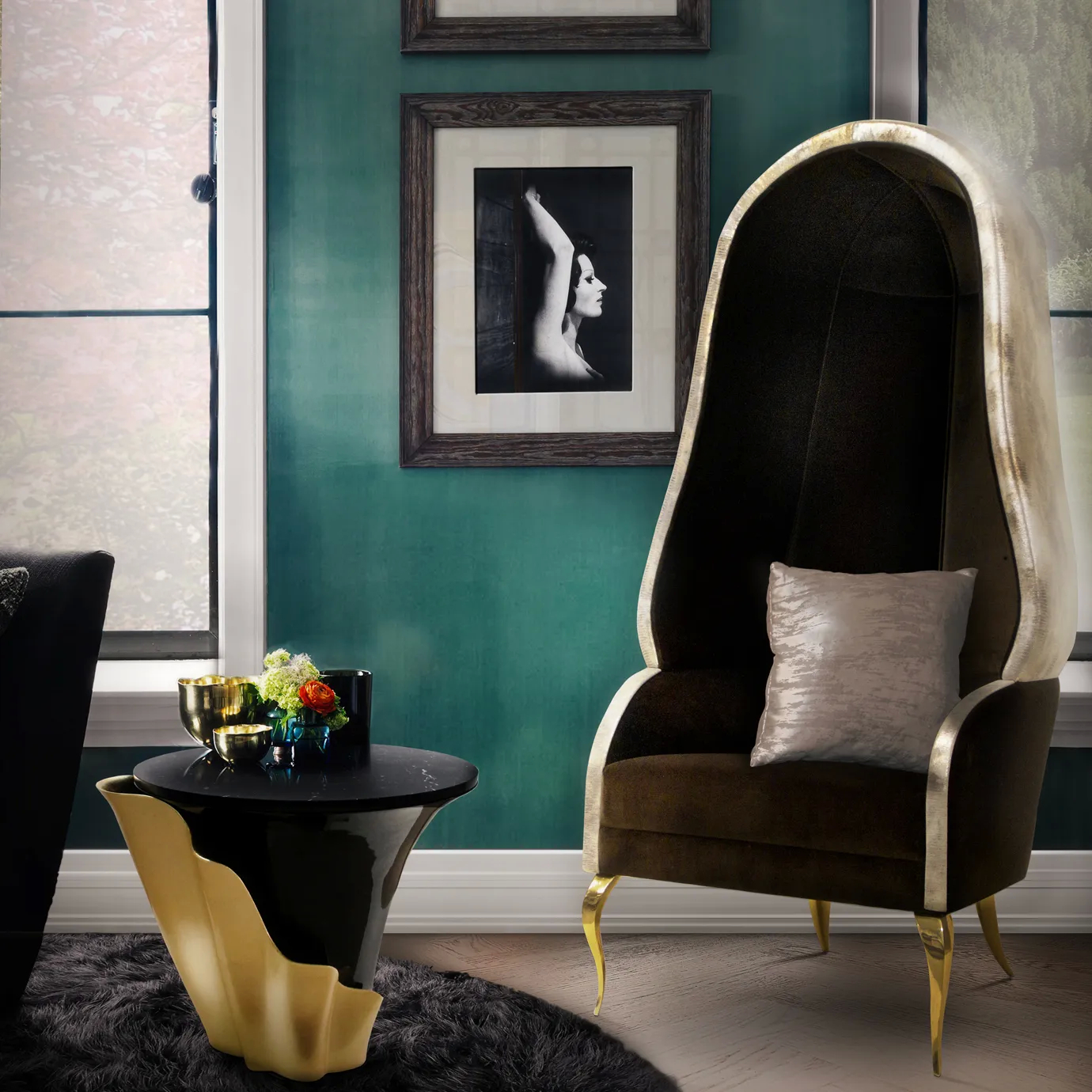 The Drapesse Leather Back Chair in a stylish room with a dark teal wall, framed art, and a unique black and gold side table.