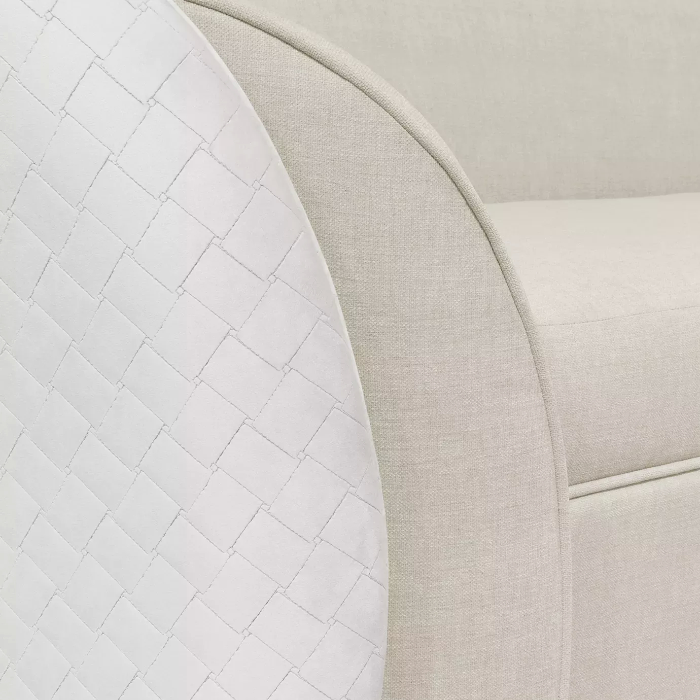 Extreme close-up of the Sultana Sofa showing the contrast between the light fabric and the quilted side panel.