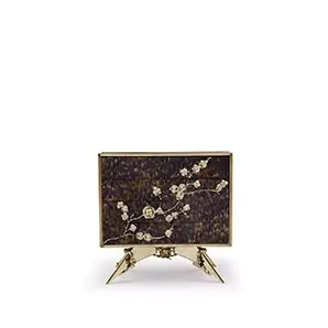 The Spellbound Peacock Purple Feather Nightstand’s structure is adorned with purple feathers ornamented with elegant golden flower-shaped details along the front of the four drawers.
