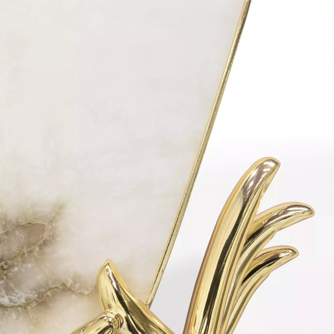 Close-up of the Muse Alabaster Sconce, highlighting its elegant gold hand holding an alabaster shade.