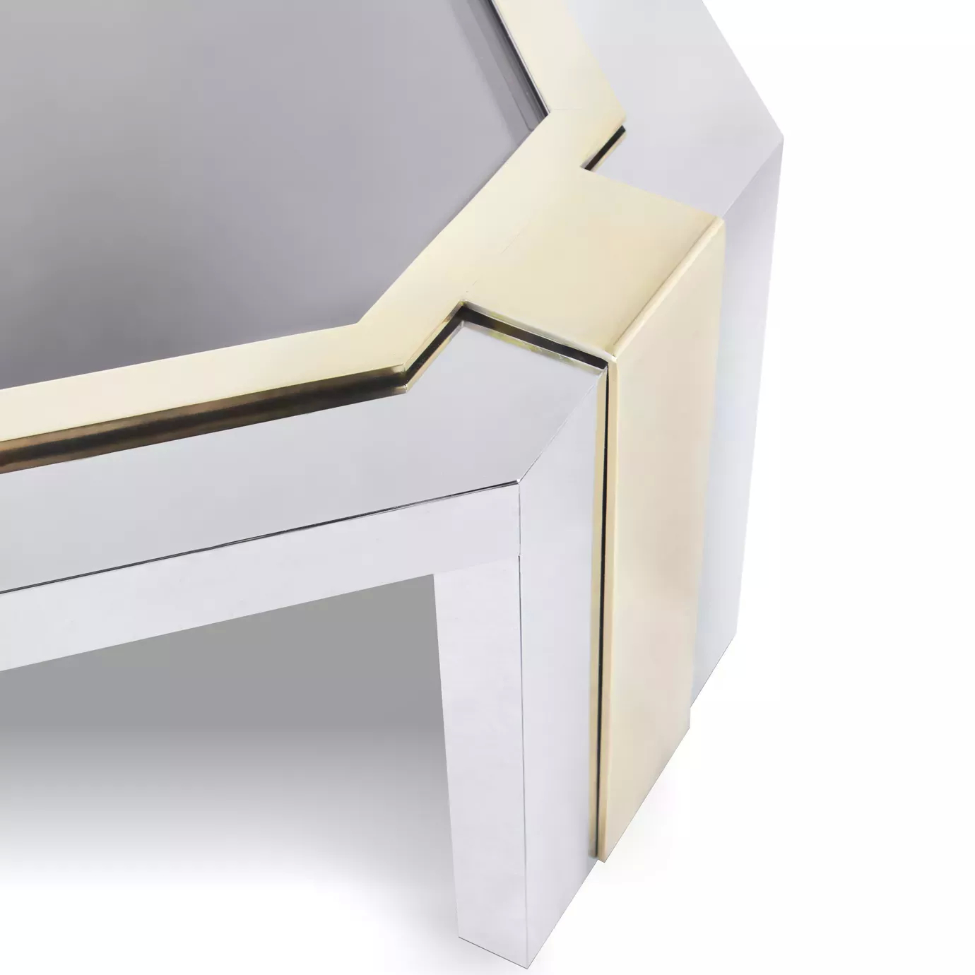 Elegant close-up of the dark glass top and geometric stainless steel frame with golden details of the Minx Coffee Table.