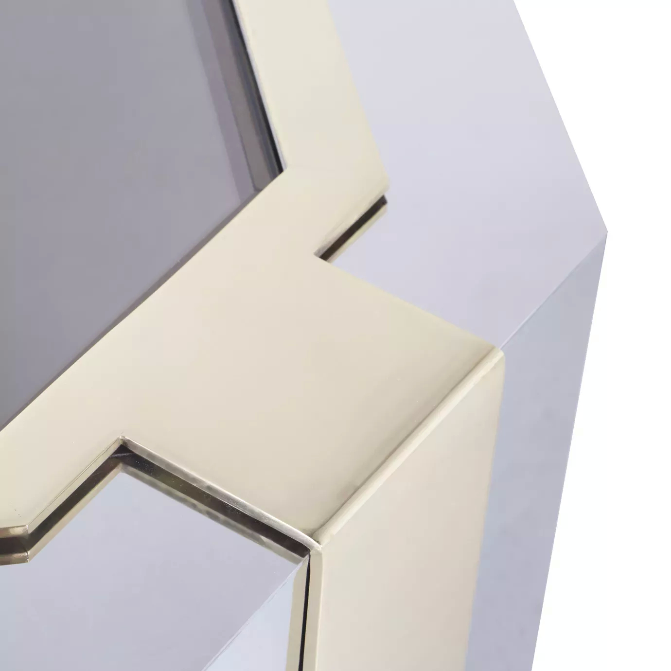 Elegant close-up of the dark glass top and geometric stainless steel frame with golden details of the Minx Coffee Table.